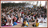  Devotees in the assembly hall engaged in Swamishri's puja darshan