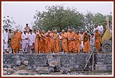  Swamishri places a stone in the foundation pit and offers his service