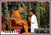 Swamishri attentively listens to a balak who has remained firm in his niyam-dharma 	