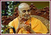 Swamishri claps his hands to kirtans as balaks are sprayed with colored water 
