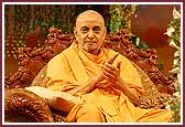 Swamishri claps his hands to kirtans as balaks are sprayed with colored water 
