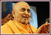 Swamishri claps his hands to kirtans as balaks are sprayed with colored water 