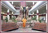 Swamishri in front of a large murti of Neelkanth Varni as well as smaller murtis to be given out as mementos