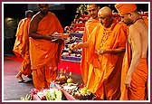 morning ,Swamishri throws flowers on the annakut offering and sanctifies the food items 	