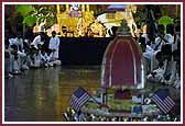 Evening ,Swamishri controls a remote-controlled Rath with Shri Harikrishna Maharaj in it 	