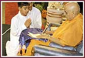 Evening,Swamishri signs his name on his convention passport 