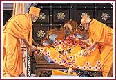 Senior saints present Swamishri with a shawl made by the Mahila Mandal 	