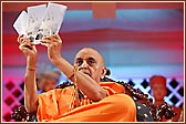  Swamishri holds up the new leaflets for BAPS Shri Swaminarayan Mandir