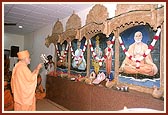 Swamishri performs the murti-pratishtha arti in the assembly hall of chhatralay