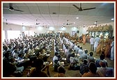 Swamishri performs the murti-pratishtha arti in the assembly hall of chhatralay