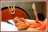 Despite his ailing health, Swamishri attends to a telephone and a correspondence