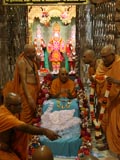 Sadhus honor Swamishri with a shawl and a garland of rakhis