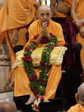 Senior sadhus honor Swamishri with a garland