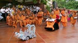 Swamishri drives the remote-controlled chariot of Harikrishna Maharaj accompanied by children
