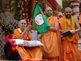 Swamishri waves a flag for the rathyatra to begin
