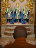 Swamishri engrossed in darshan of Bhagwan Swaminarayan, Aksharbrahman Gunatitanand Swami and Shri Gopalanand Swami 