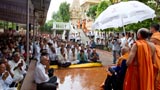 A brief rain shower does not dampen the enthusiasm of devotees for Swamishri's darshan