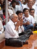 A brief rain shower does not dampen the enthusiasm of devotees for Swamishri's darshan