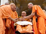 Pujya Ishwarcharan Swami ties a rakhdi on Swamishri's wrist, on behalf of all devotees