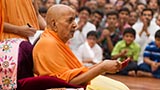 Swamishri holds a lamp in his hand
