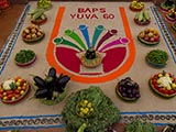  Vegetables arranged around a rangoli of the 'BAPS Yuva 60' logo