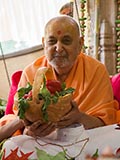  Swamishri holding various fruits and vegetables offered to Thakorji