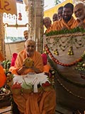  Swamishri holding various fruits and vegetables offered to Thakorji