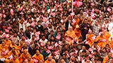 Sadhus and devotees wave flags commemorating 60 years of BAPS Youth Activities