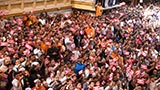 Sadhus and devotees wave flags commemorating 60 years of BAPS Youth Activities
