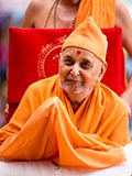 A shawl protects Swamishri's hands from the cold breeze.  
