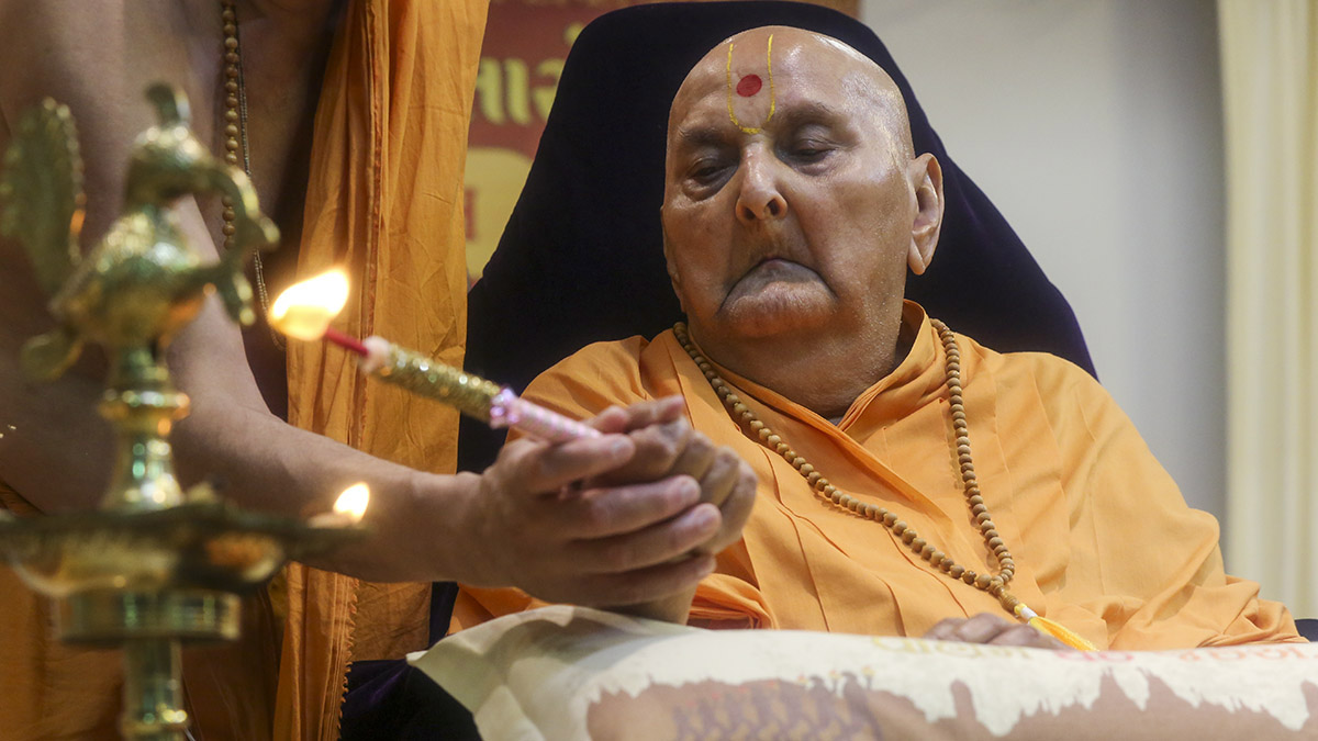Swamishri lighting the inaugural lamp (deep-pragatya) at the start of the Yuva Talim Kendra