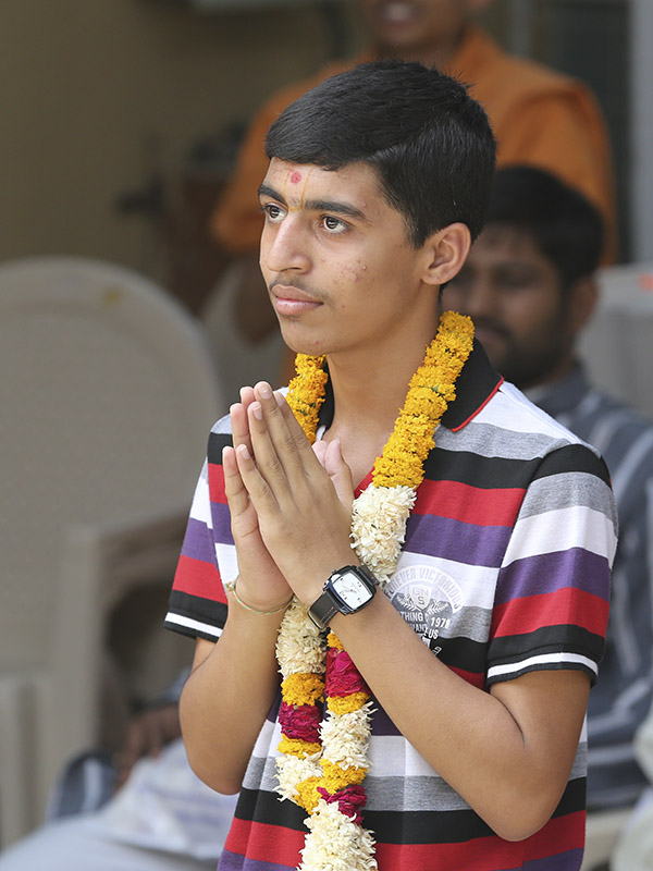 Dharmik Parmar, a student of Swaminarayan Vidyamandir, Sarangpur, who stood first in the SSC State Board (Standard 10) exams in the 99.99 percentile, doing darshan of Swamishri