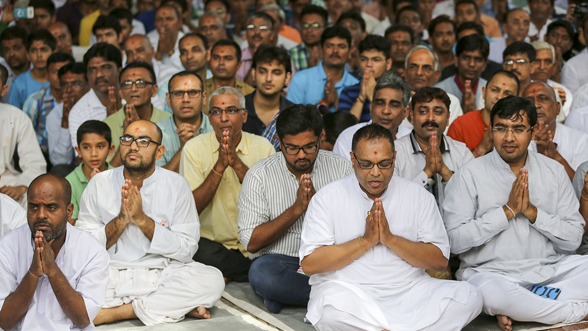 Devotees engaged in prayer during darshan of Swamishri
