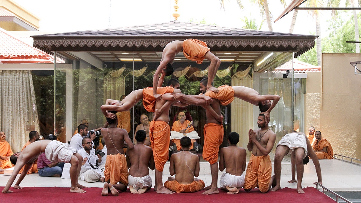 Sadhus and parshads perform yogasanas (yogic exercises) before Swamishri, on the occasion of International Yoga Day