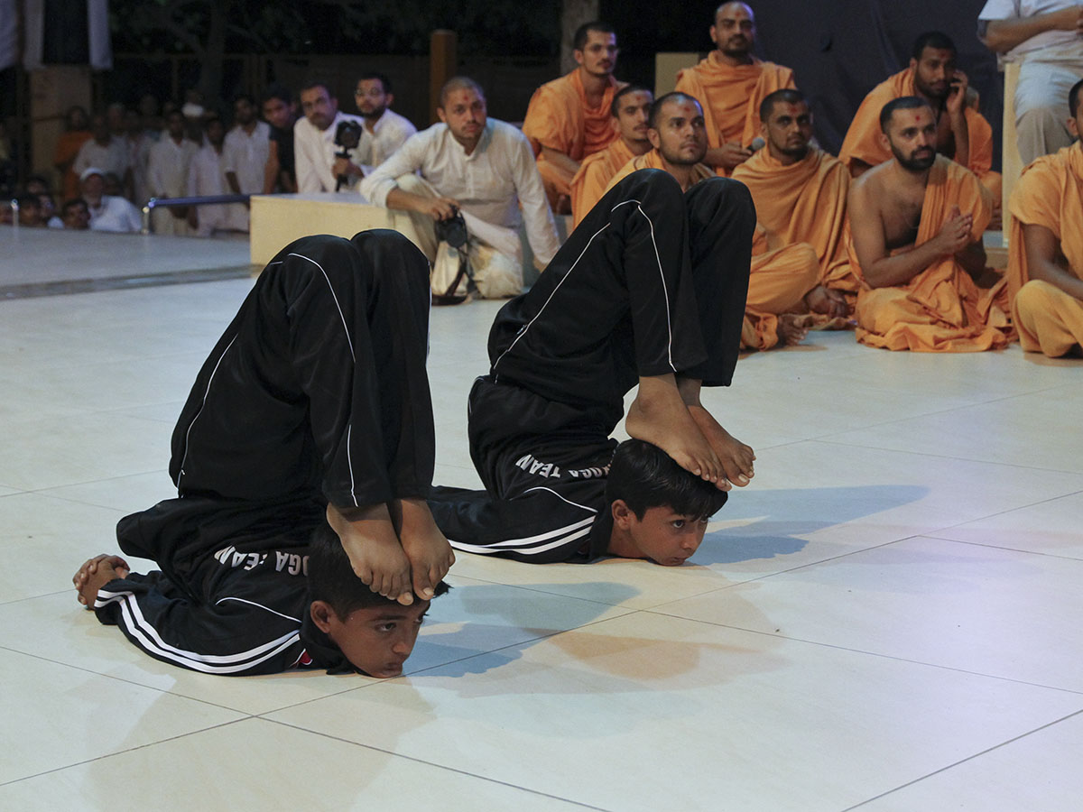 Children from Botad Bal Mandal perform yogic exercises before Swamishri on the occasion of International Yoga Day