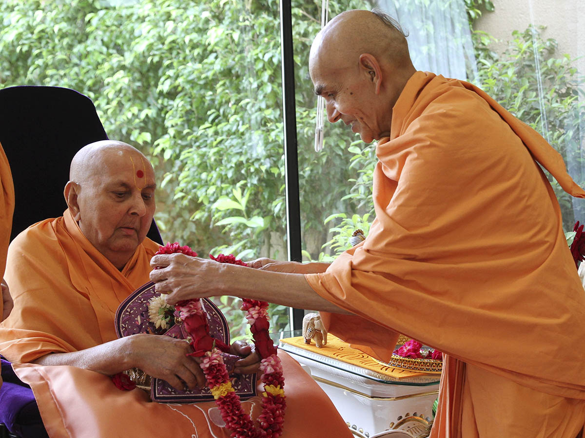 Pujya Keshavajivan Swami (Pujya Mahant Swami ) honors Shri Harikrishna Maharaj with a garland