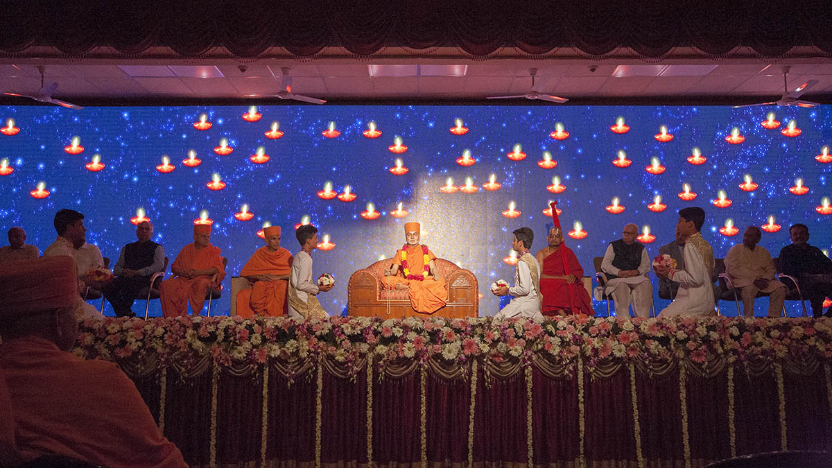 Children sing Sanskrit shlokas while holding oil lamps to traditionally dedicate and inaugurate the book