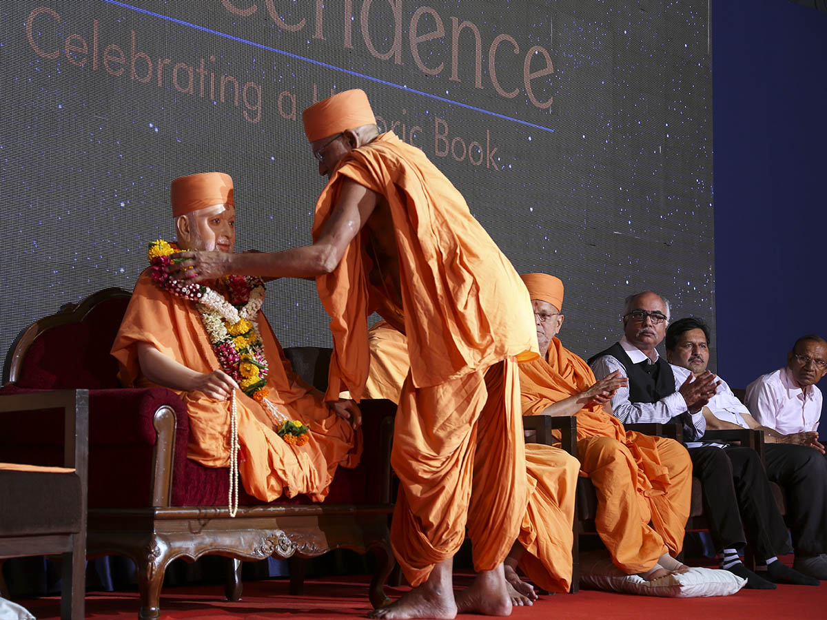 Swamishri's utsav murti is honored with a garland