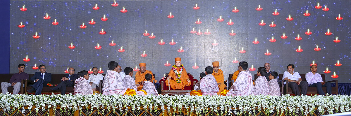 Children sing Sanskrit shlokas while holding oil lamps to traditionally dedicate and inaugurate the book
