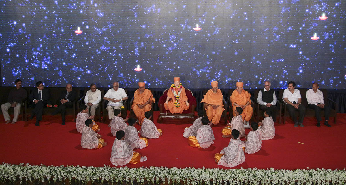Children sing Sanskrit shlokas while holding oil lamps to traditionally dedicate and inaugurate the book