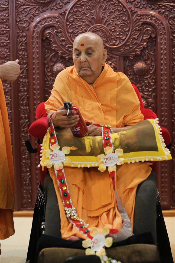 Swamishri sanctifying National Bal-Balika Mandal Shibir mementoes, Sarangpur, India