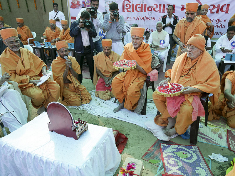 Pujya Mahant Swami and Pujya Ishwarcharan Swami perform arti