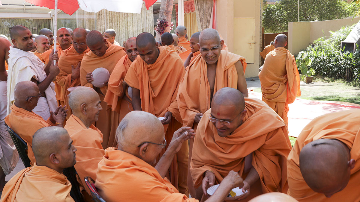 Senior sadhus give prasad to sadhus