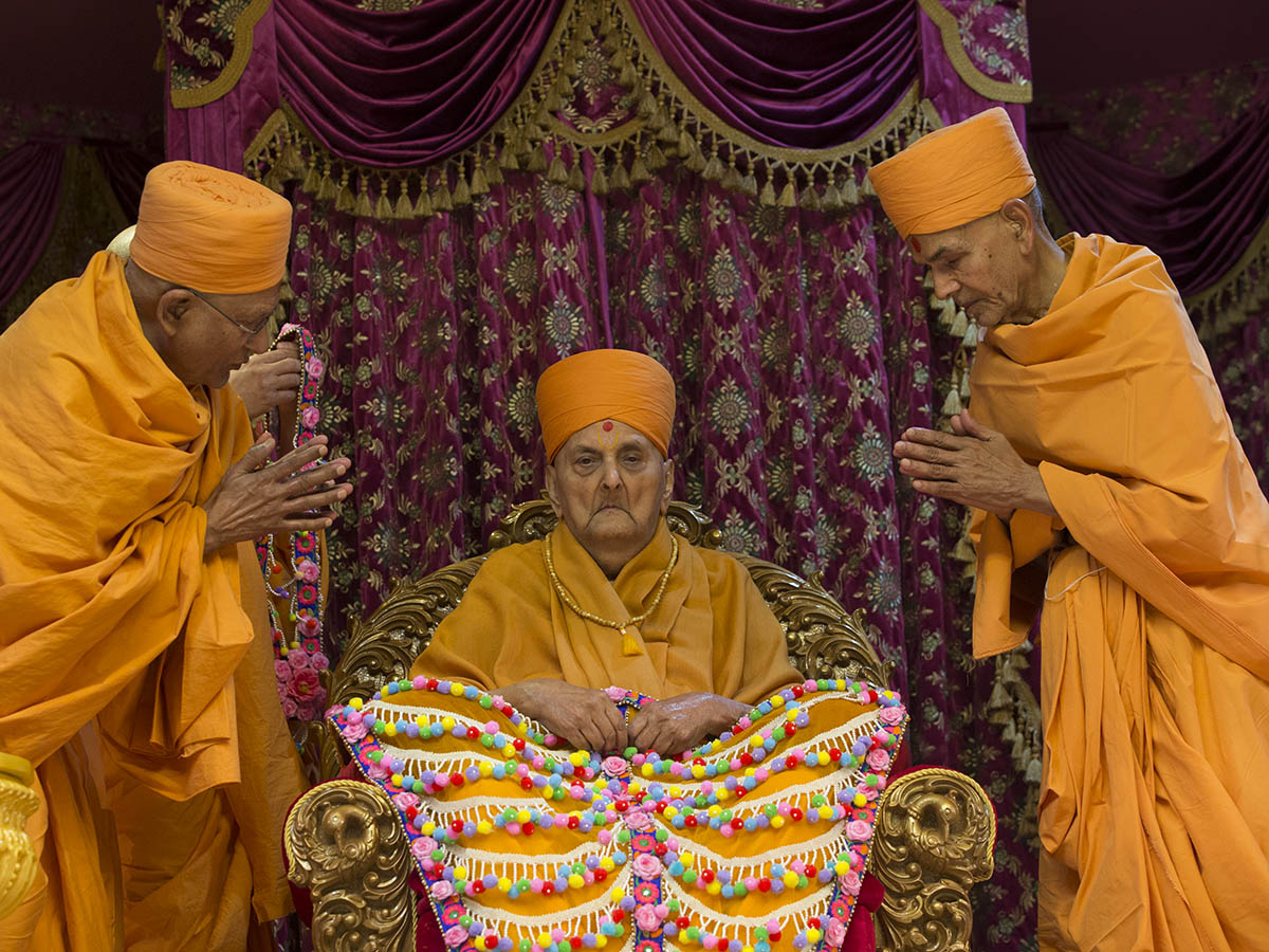 Pujya Mahant Swami and Pujya Kothari Swami honor Swamishri with a  shawl of flowers