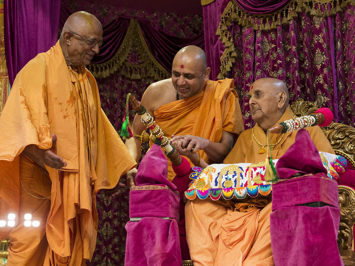 Swamishri showers sanctified colored water on Pujya Doctor Swami