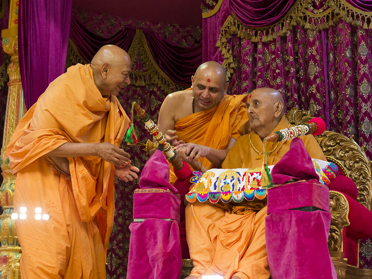 Swamishri showers sanctified colored water on Pujya Tyagvallabh Swami