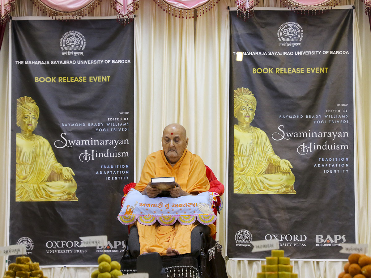 Swamishri sanctifies an Oxford University Press print publication, 'Swaminarayan Hinduism: Tradition, Adaptation, Identity'