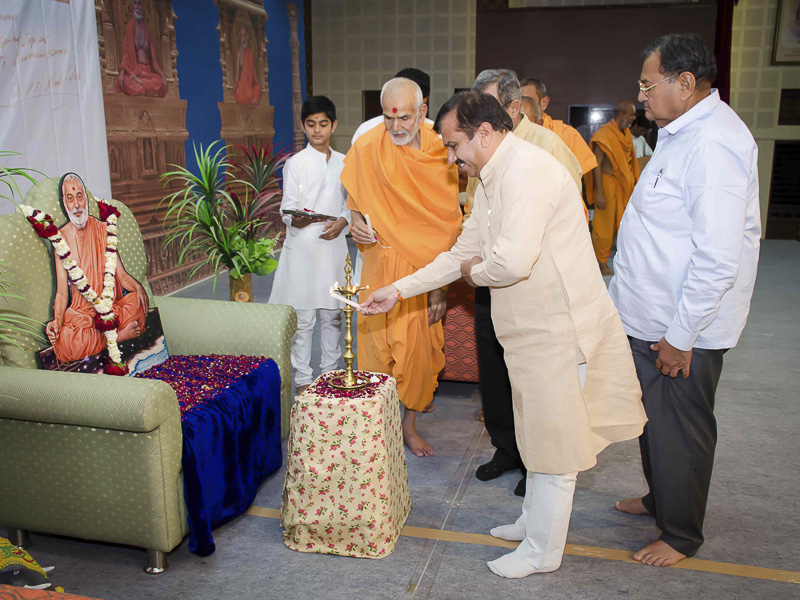 Pujya Mahant Swami and Shri Harinarayan Yadav light the inaugural lamp