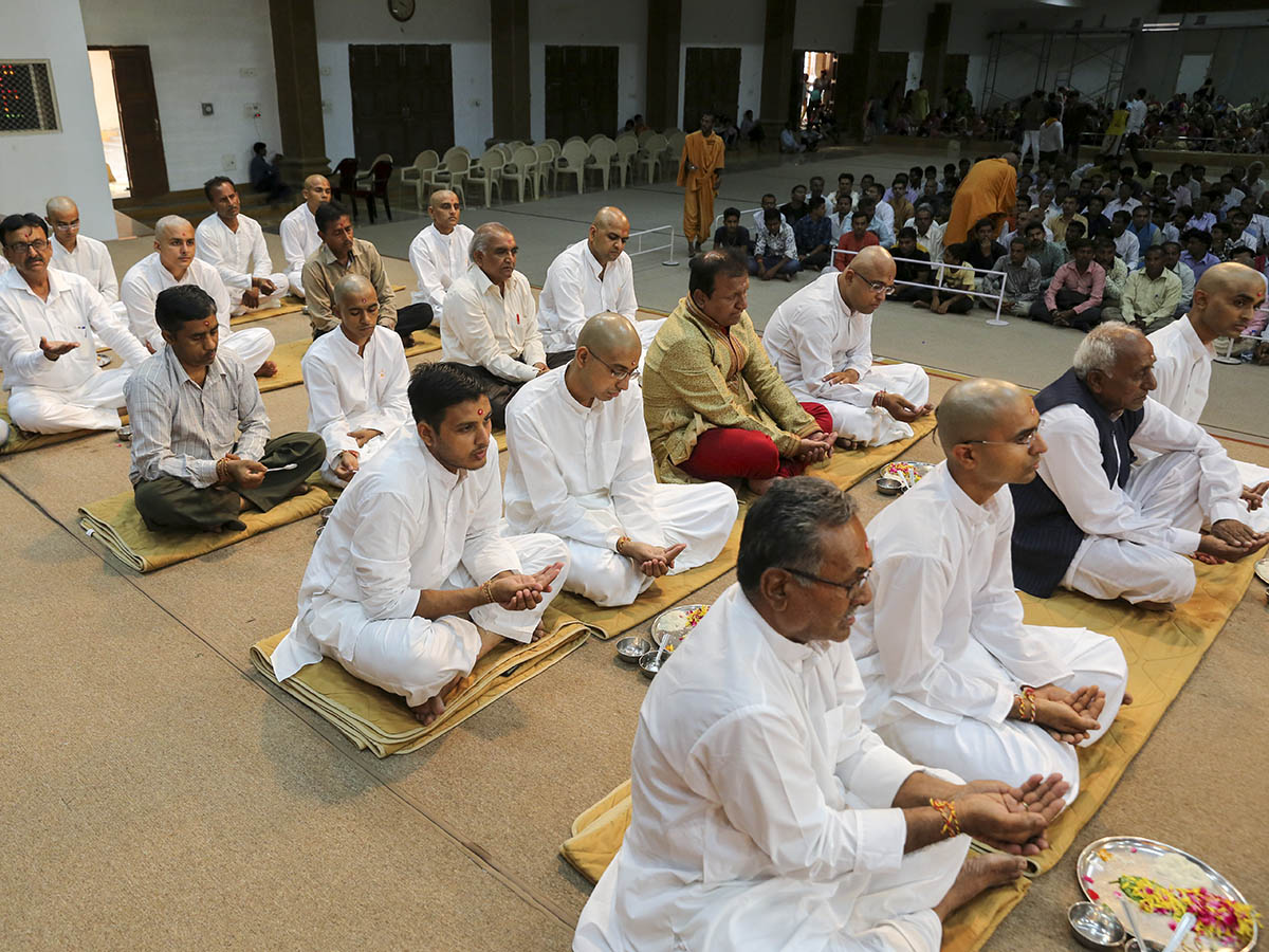 Sadhaks and their fathers engaged in mahapuja rituals before being initiated as parshads