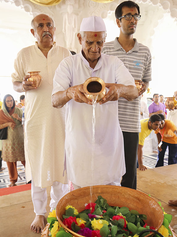 Devotees perform abhishek of murtis